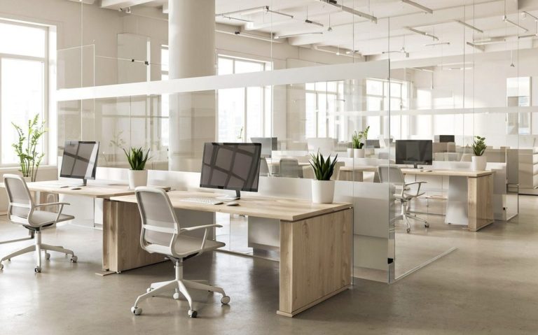 Helles, modernes Büro mit Tischen, Computerarbeitsplätzen und Pflanzen.